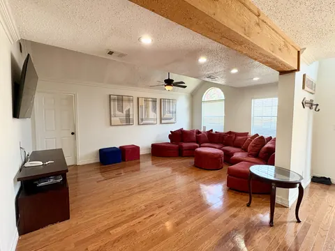 Living room with sectional seating and television at Directions Sober Living House