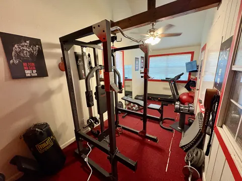 On-site fitness room with squat rack, bench and free weights